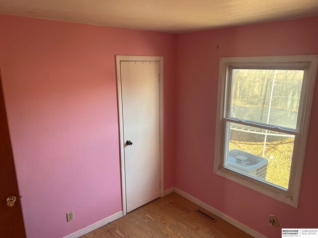 spare room with visible vents, light wood-style flooring, and baseboards