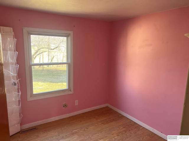 empty room with visible vents, baseboards, and wood finished floors