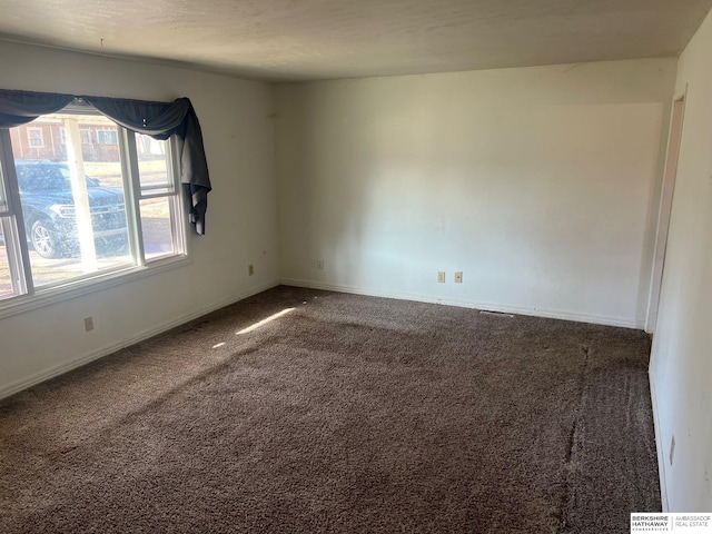 carpeted spare room featuring baseboards