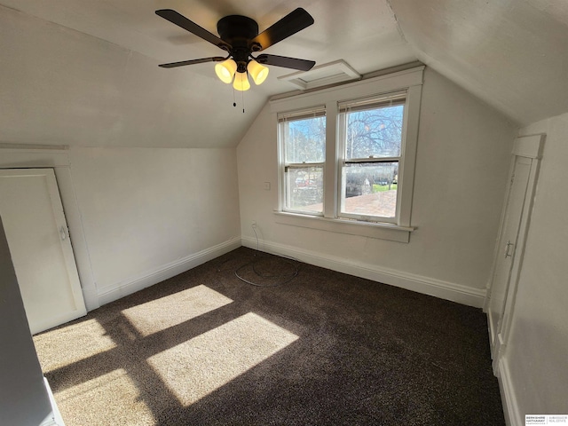 bonus room with dark carpet, baseboards, and vaulted ceiling