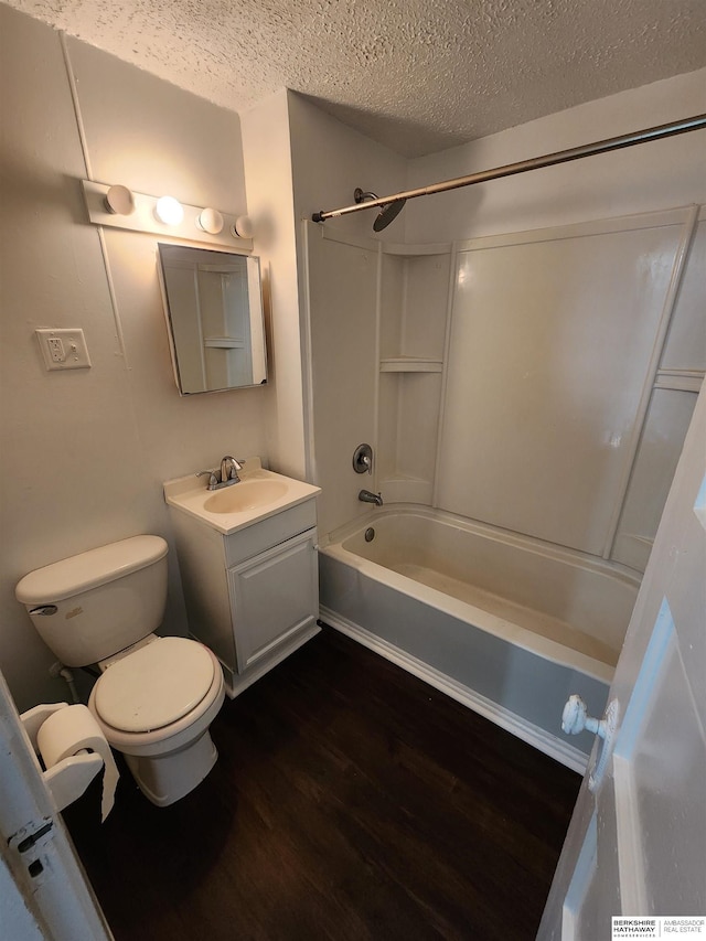 full bath featuring toilet, vanity, wood finished floors, a textured ceiling, and  shower combination