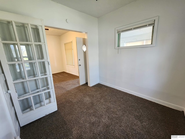 carpeted spare room featuring baseboards