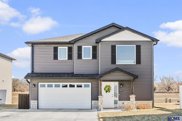 view of front of house featuring concrete driveway, stone siding, a garage, and roof with shingles