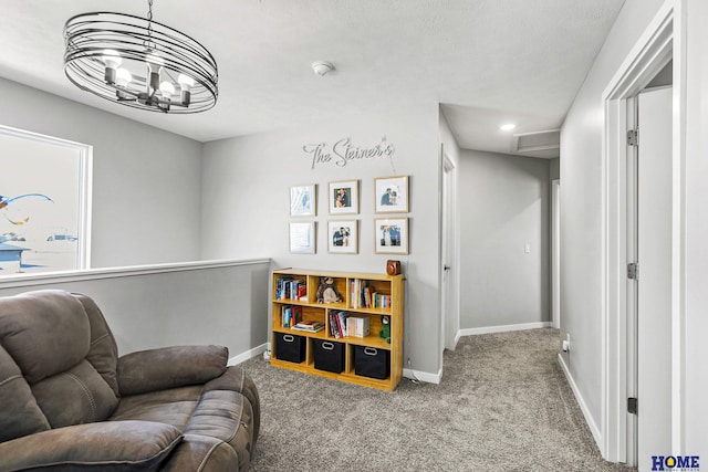 sitting room featuring an inviting chandelier, baseboards, and carpet