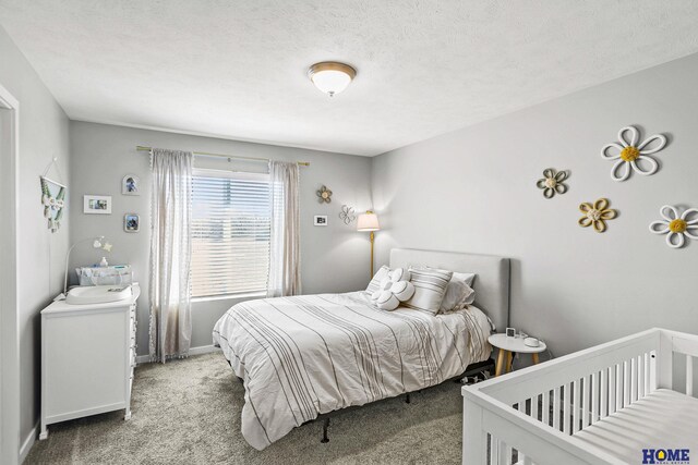 carpeted bedroom featuring baseboards and a textured ceiling