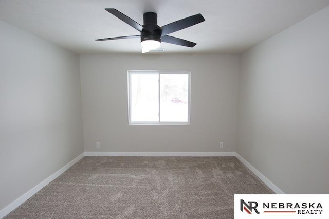 carpeted empty room featuring visible vents, ceiling fan, and baseboards