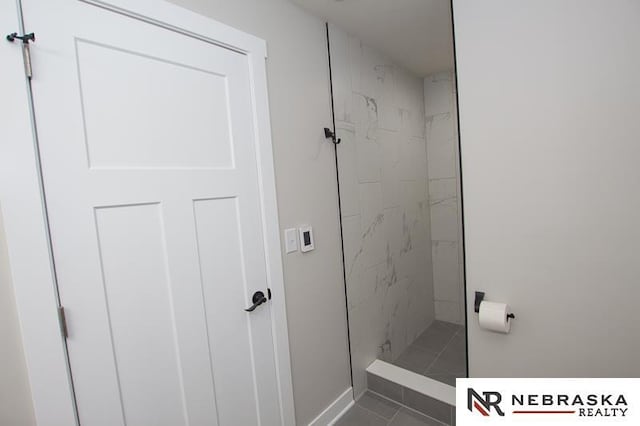 full bathroom featuring a marble finish shower