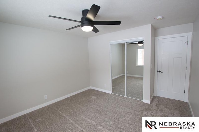 unfurnished bedroom with a closet, carpet flooring, ceiling fan, and baseboards