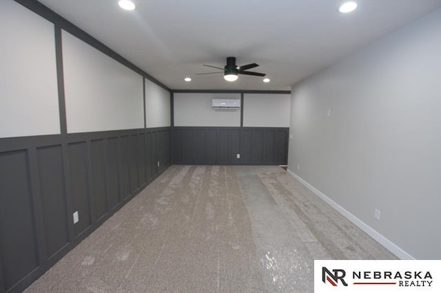 carpeted spare room featuring a wall unit AC, recessed lighting, baseboards, and ceiling fan