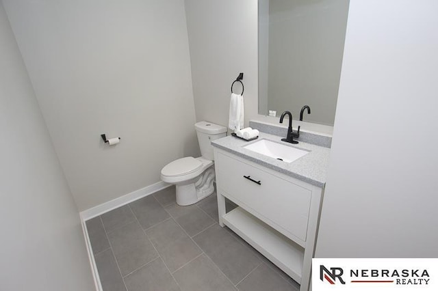 bathroom with baseboards, toilet, vanity, and tile patterned flooring