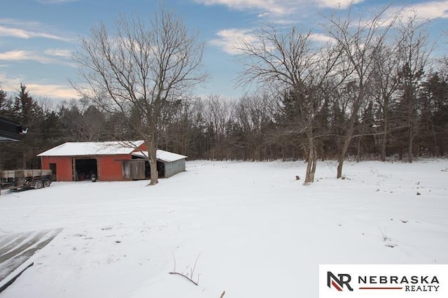 yard layered in snow with a detached garage, an outbuilding, and an outdoor structure