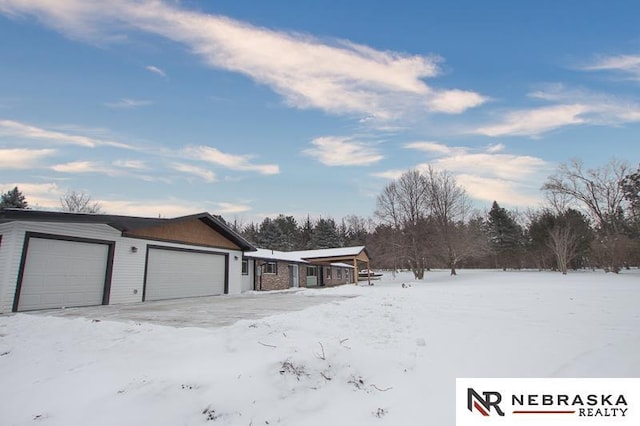 view of snowy exterior with a garage