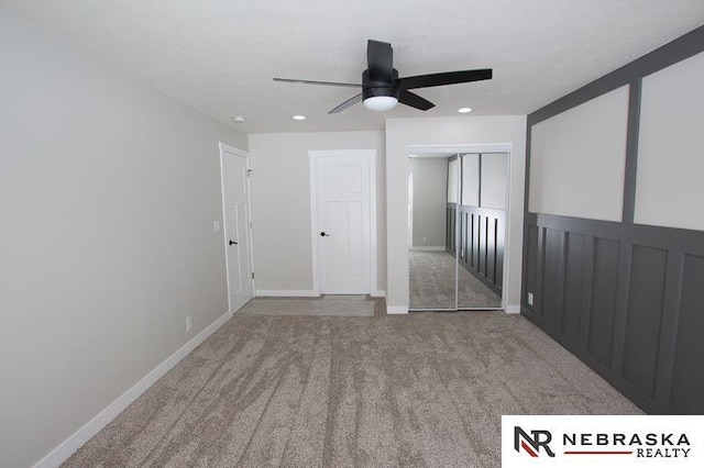 unfurnished bedroom featuring a closet, baseboards, carpet, and a ceiling fan