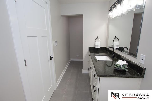 bathroom with tile patterned floors, baseboards, and vanity