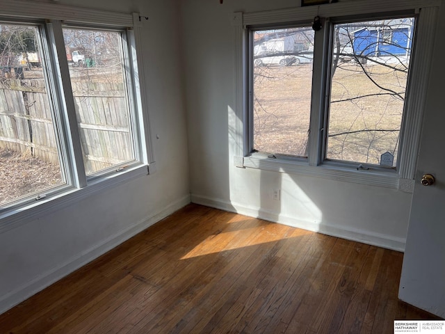 unfurnished room featuring baseboards and hardwood / wood-style floors