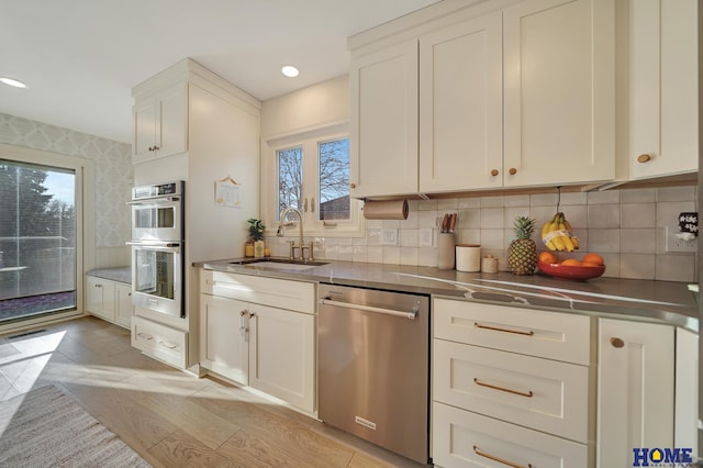 kitchen with tasteful backsplash, stainless steel counters, appliances with stainless steel finishes, and a sink