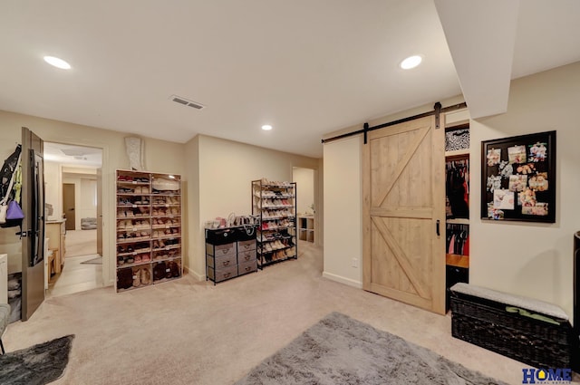 interior space featuring a barn door, carpet flooring, recessed lighting, and visible vents