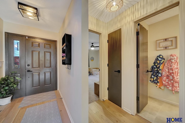 foyer entrance featuring baseboards and light wood-style floors