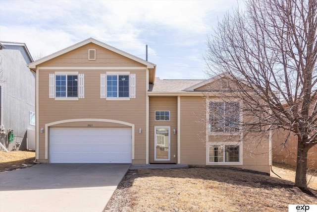 tri-level home with concrete driveway and a garage