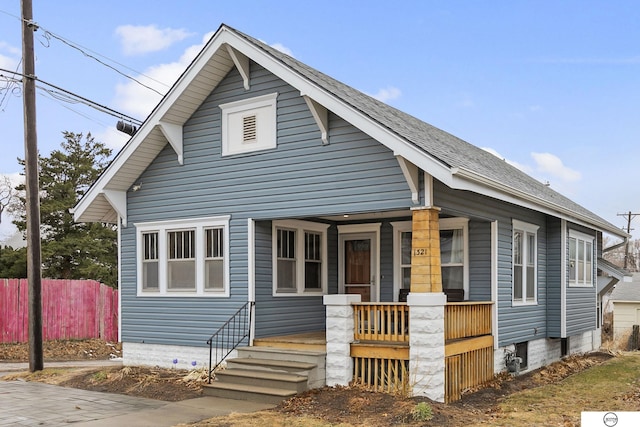 bungalow featuring a porch and fence