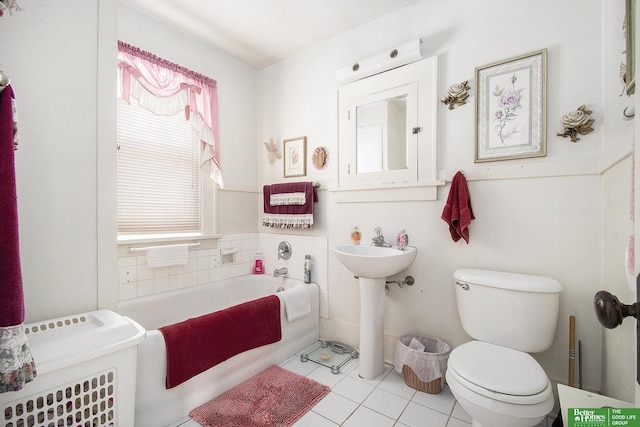 full bath with tile patterned flooring, toilet, a garden tub, and a sink