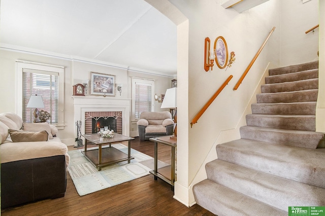 living area featuring stairway, a fireplace, and wood finished floors