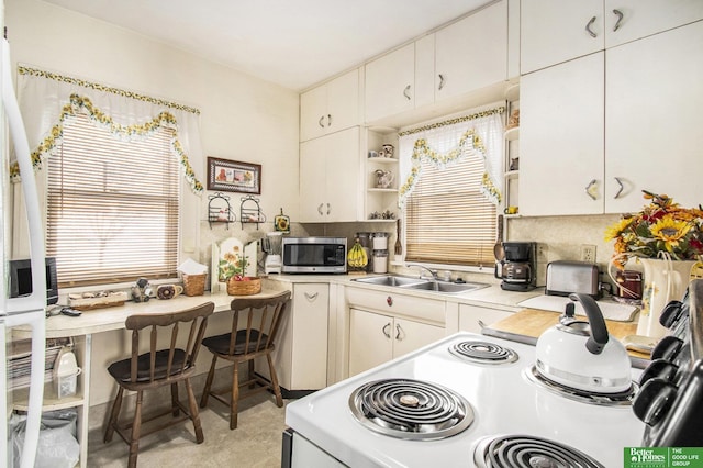 kitchen featuring open shelves, a sink, light countertops, electric stove, and stainless steel microwave