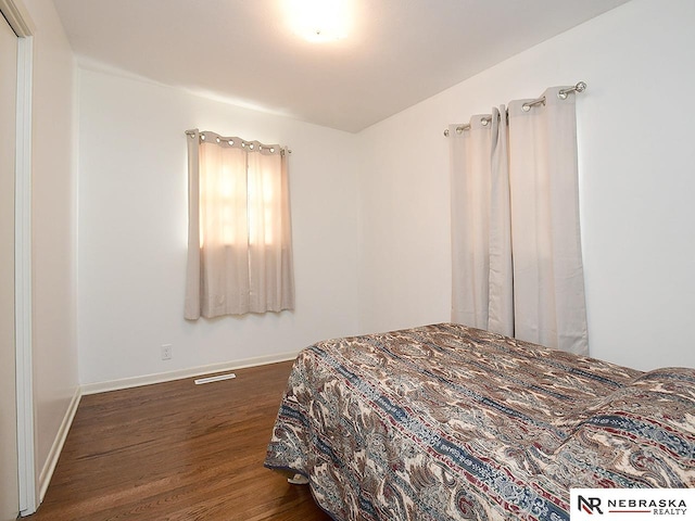 bedroom featuring wood finished floors and baseboards