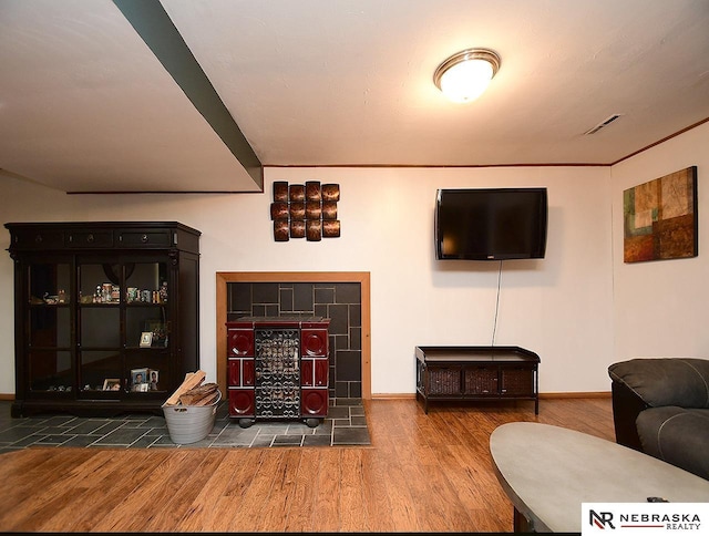 living area featuring wood finished floors, visible vents, and baseboards