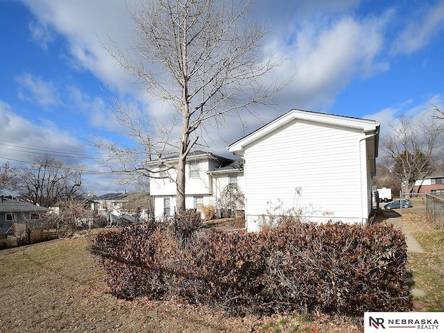 view of home's exterior with a yard and fence