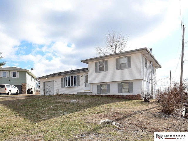 split level home featuring a front lawn and a garage