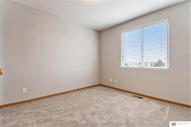 spare room with visible vents, baseboards, and light colored carpet