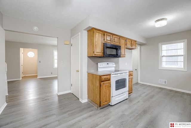 kitchen with visible vents, light countertops, electric stove, black microwave, and light wood-type flooring