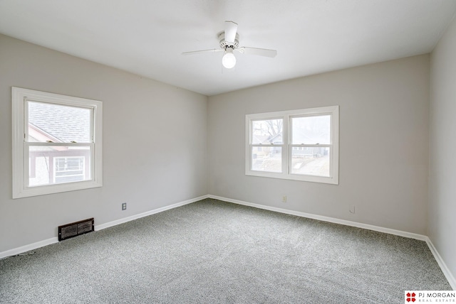 carpeted empty room featuring a ceiling fan, baseboards, and visible vents