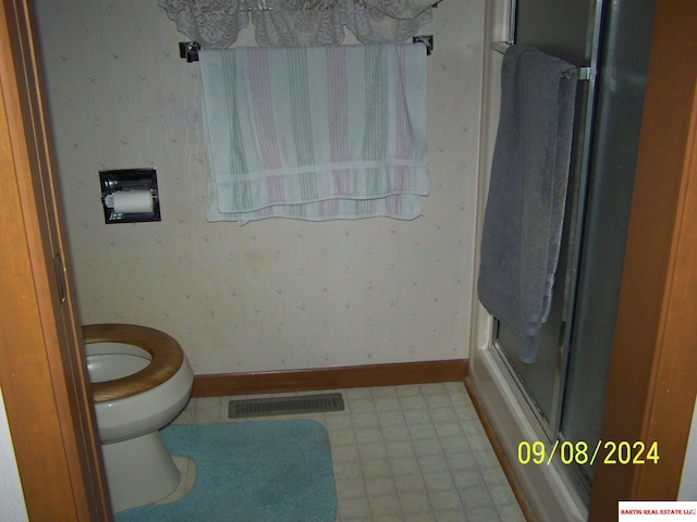 bathroom featuring visible vents, baseboards, toilet, tile patterned floors, and an enclosed shower