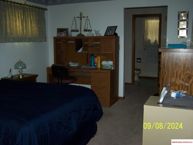 bedroom with light carpet, ensuite bathroom, and baseboards