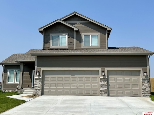 craftsman-style house featuring stone siding, concrete driveway, and a garage