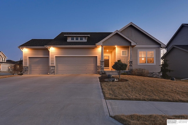 craftsman house featuring stone siding, concrete driveway, and an attached garage