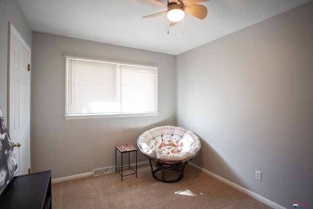 living area with visible vents, ceiling fan, baseboards, and carpet