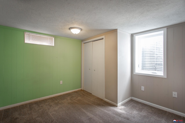 unfurnished bedroom with a closet, baseboards, carpet, and a textured ceiling