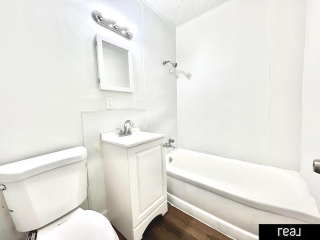 bathroom featuring vanity, toilet, wood finished floors, and a tub