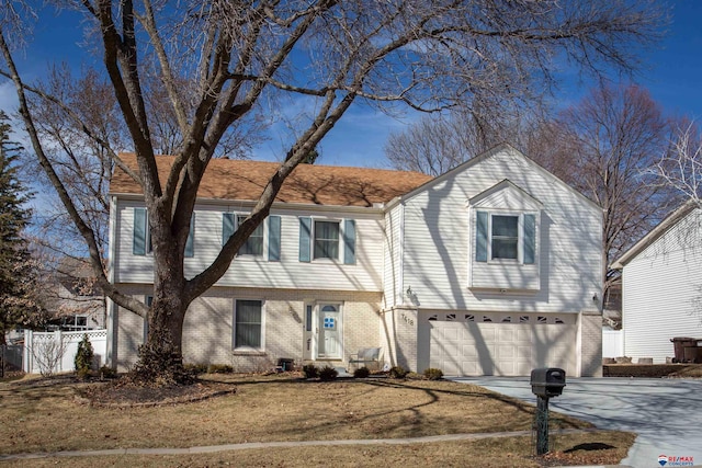 view of front of house featuring brick siding, driveway, a garage, and fence