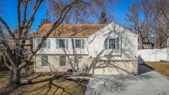 view of front of house with brick siding, an attached garage, driveway, and fence