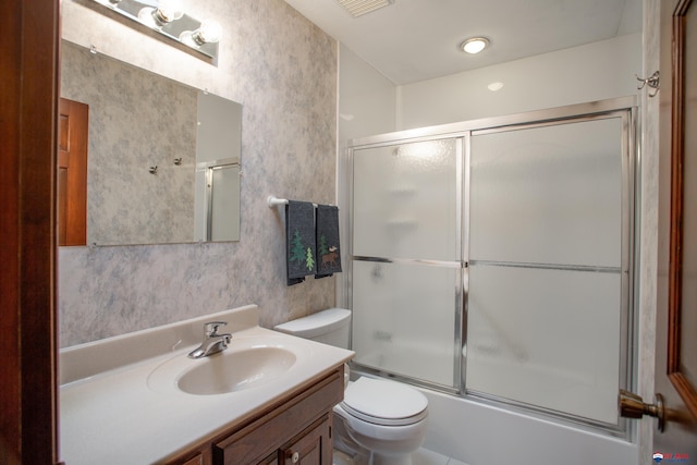 full bathroom featuring vanity, toilet, shower / bath combination with glass door, and wallpapered walls