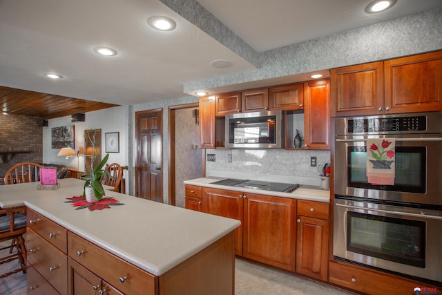 kitchen with light countertops, brown cabinetry, and stainless steel appliances