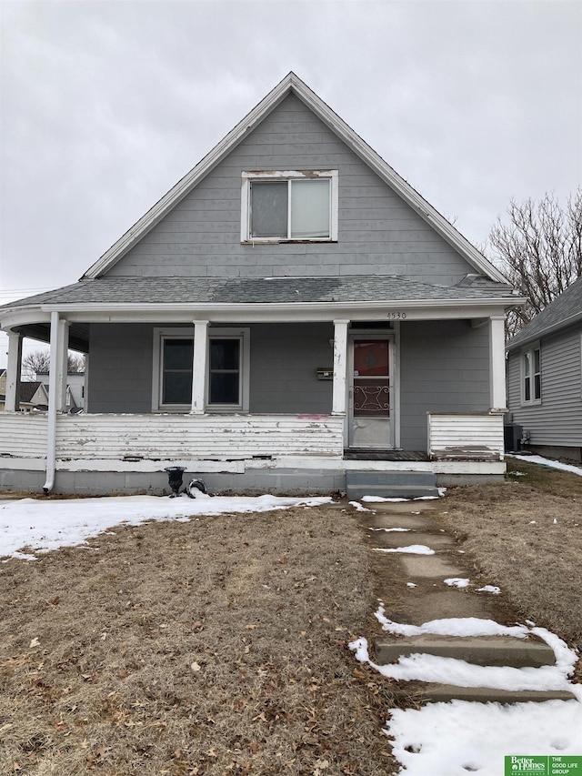 bungalow-style home featuring roof with shingles and a porch