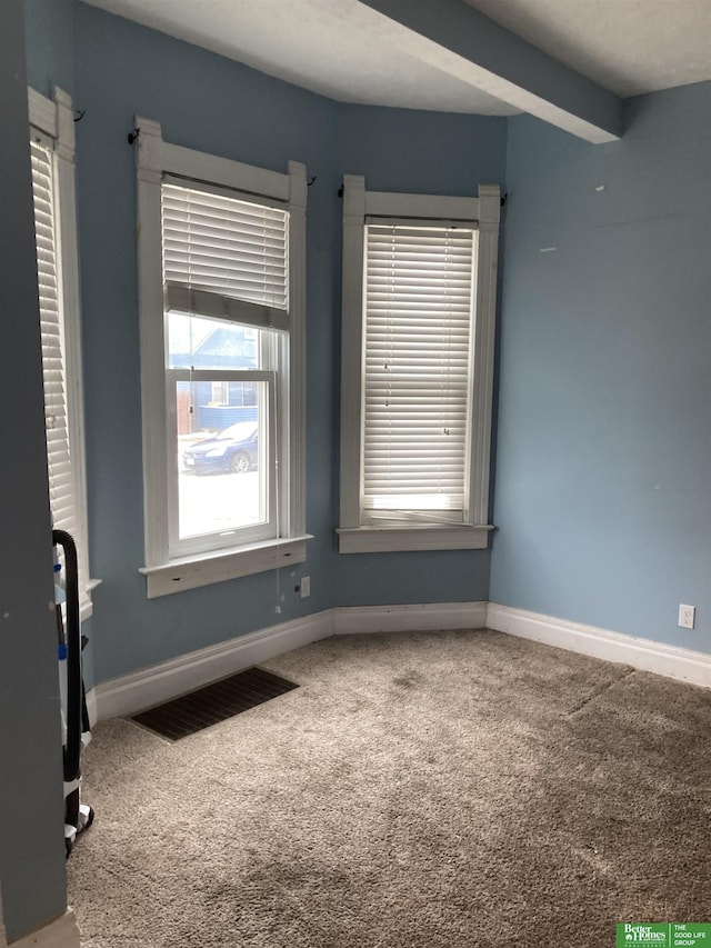 interior space featuring beam ceiling, baseboards, visible vents, and carpet floors