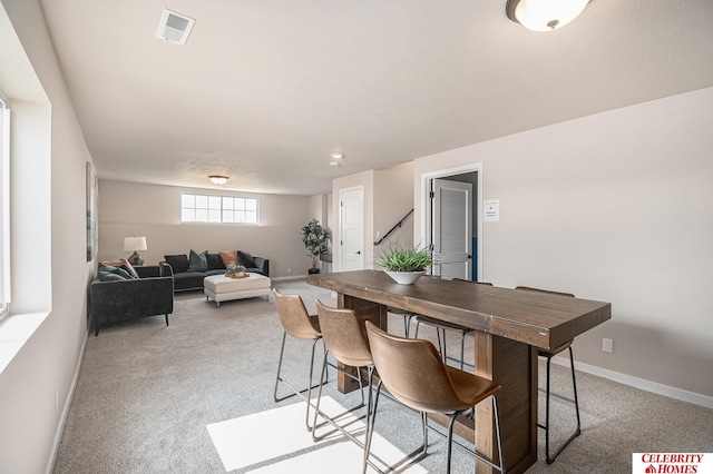 dining room featuring baseboards, visible vents, and light carpet