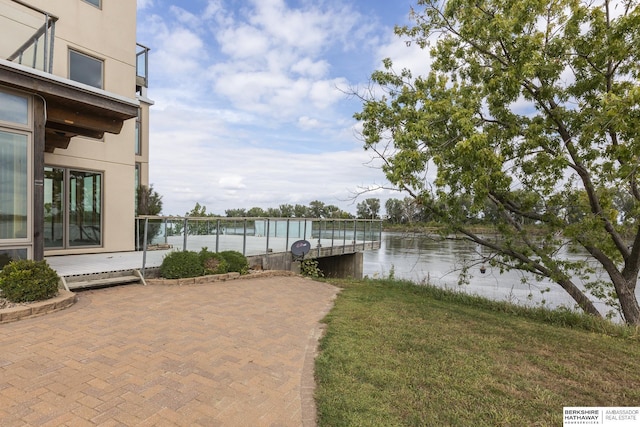 exterior space featuring a water view, a lawn, and a patio