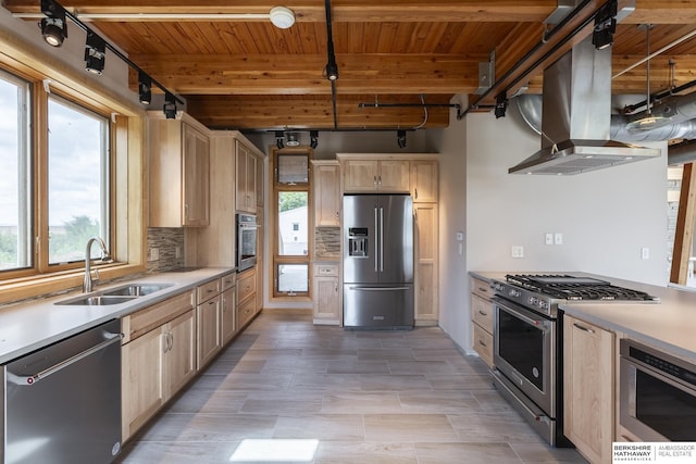 kitchen featuring tasteful backsplash, light brown cabinetry, high quality appliances, island range hood, and a sink